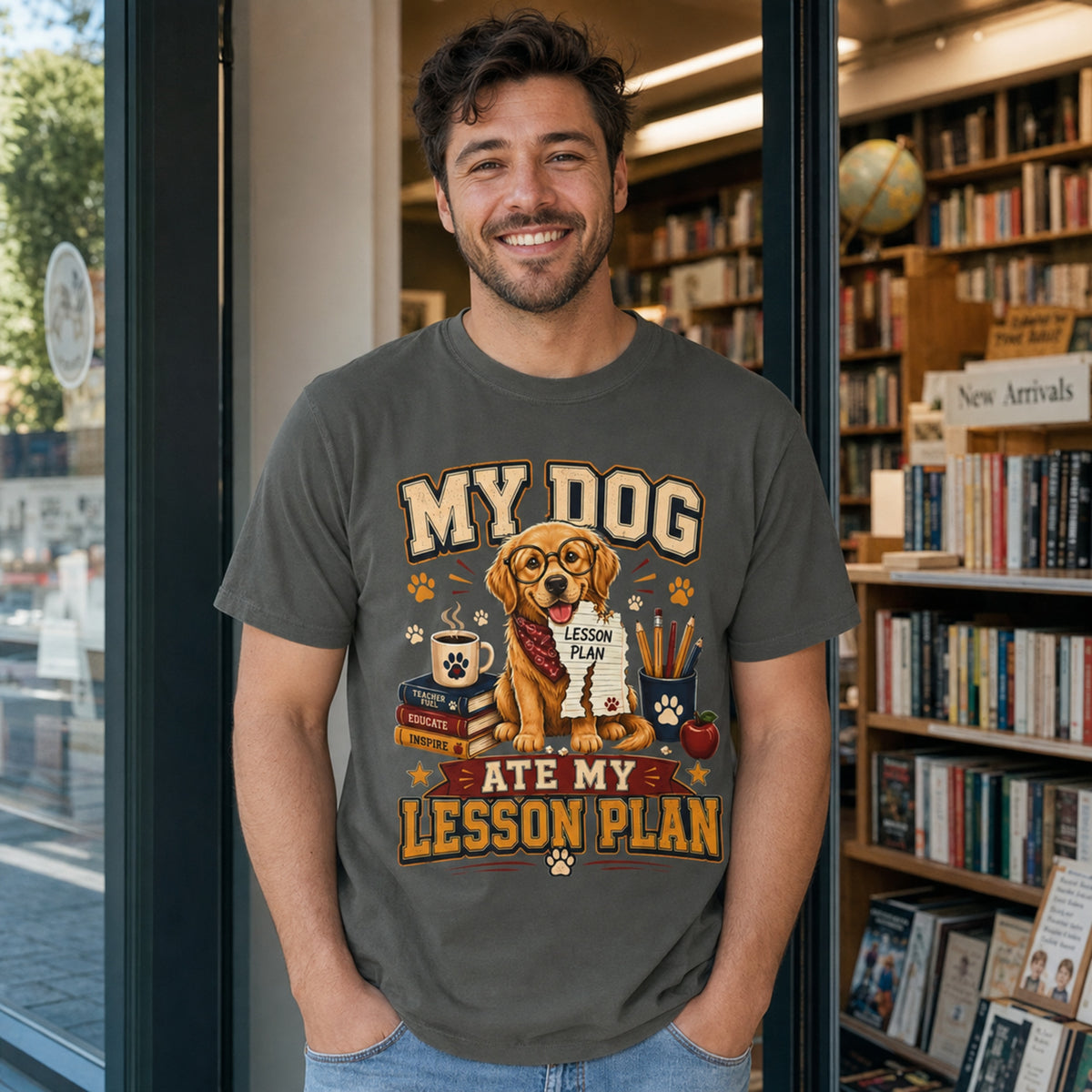 Man wearing a Pepper “My Dog Ate My Lesson Plan” T-shirt near a bookstore with golden retriever teacher artwork.