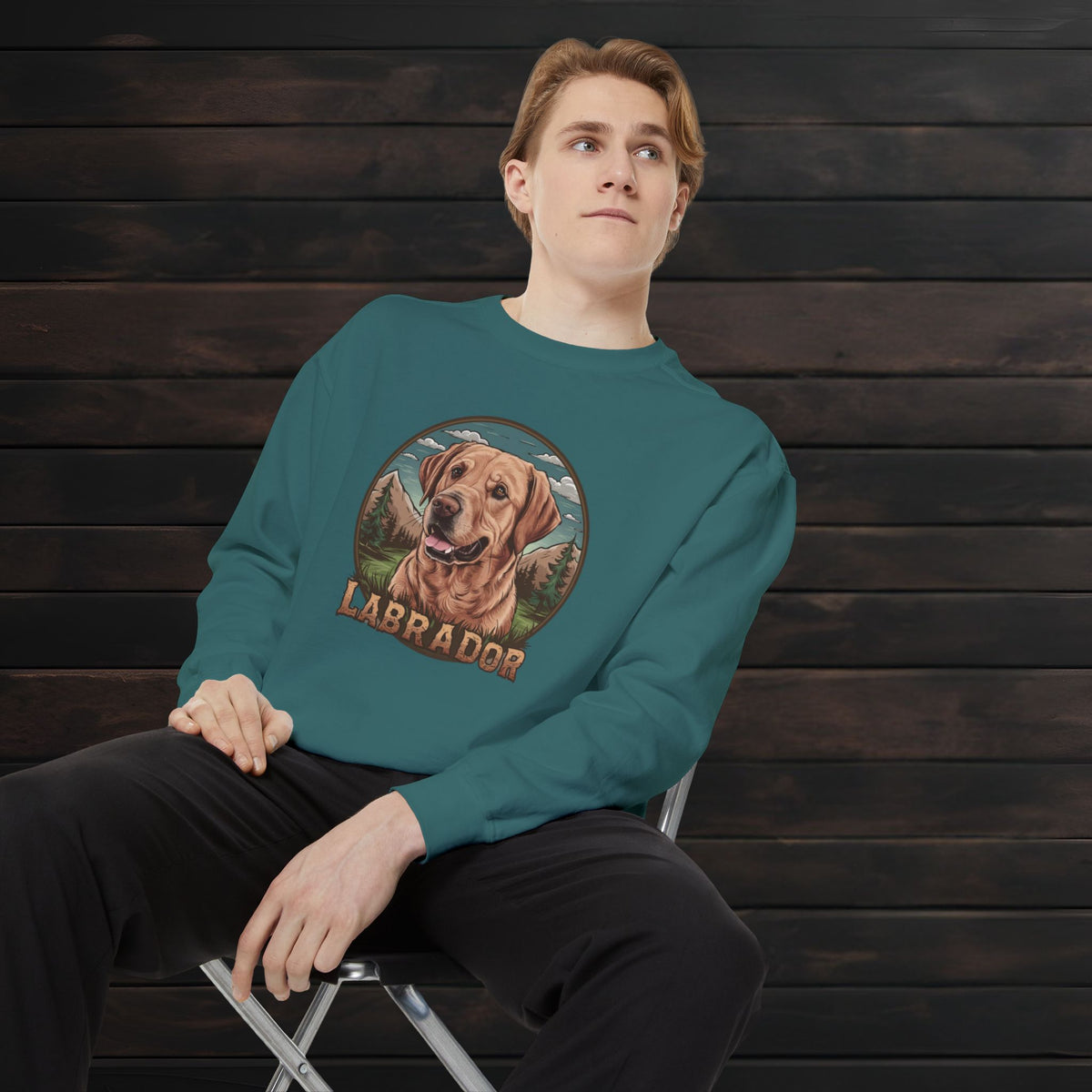 Man posing in a blue spruce unisex garment-dyed crewneck sweatshirt featuring Labrador Retriever artwork and retro-inspired pet lover design.