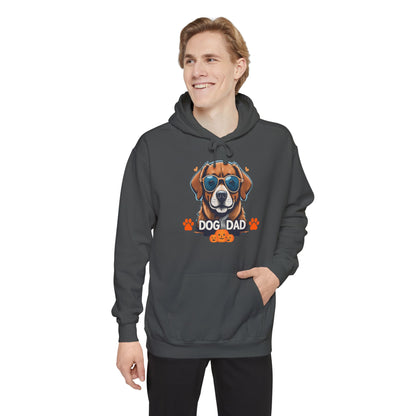 Man wearing a pepper-colored hoodie featuring a cute dog wearing sunglasses with ‘Dog Dad’ text, orange paw prints, and Halloween pumpkin graphics, casual pet lover sweatshirt for dog dads.