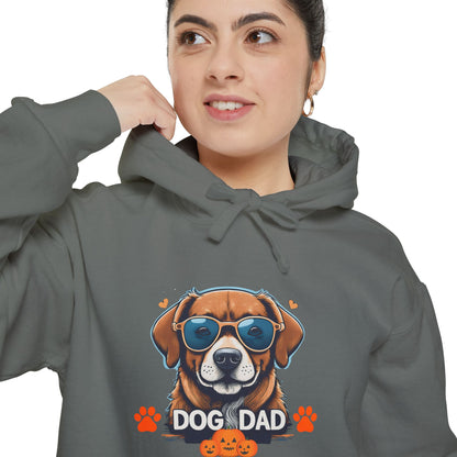 Woman wearing a grey unisex “Dog Dad” hoodie featuring vibrant dog face artwork and orange paw accents, stylish casual dog lover apparel.