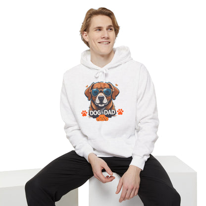 Man sitting while wearing a white unisex “Dog Dad” hoodie featuring colorful dog artwork and retro-inspired pet lover design, casual cozy fashion style.