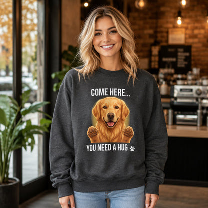 Woman wearing a dark heather Golden Retriever sweatshirt with “Come Here You Need a Hug” design inside a cafe.