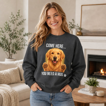 Woman wearing a dark heather Golden Retriever sweatshirt with “Come Here You Need a Hug” design in a cozy home setting.