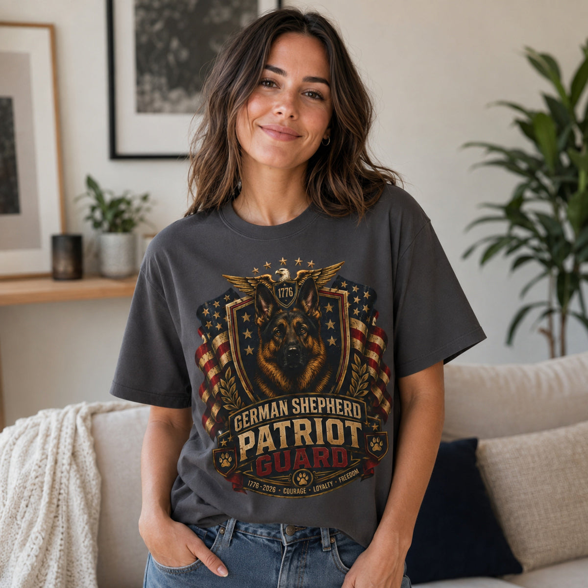 Woman wearing a graphite German Shepherd Patriot Guard T-shirt with a German Shepherd patriotic crest design in a casual living room scene.