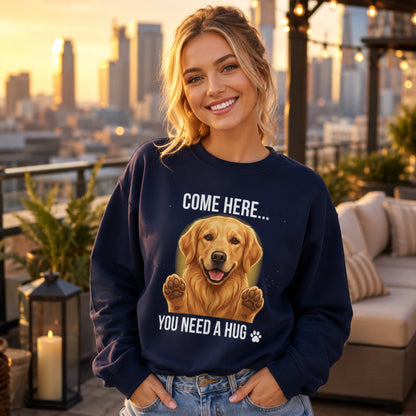 Woman wearing a navy Golden Retriever sweatshirt with “Come Here You Need a Hug” design on a rooftop at sunset.