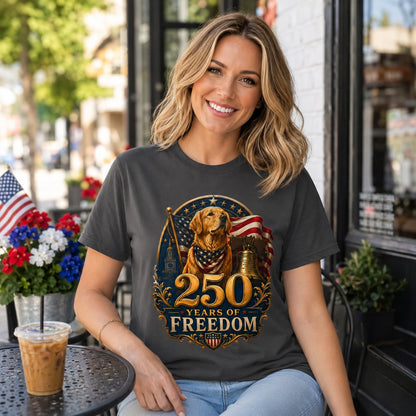 Woman smiling on a flag-lined street, wearing graphite '250 Years of Freedom' t-shirt