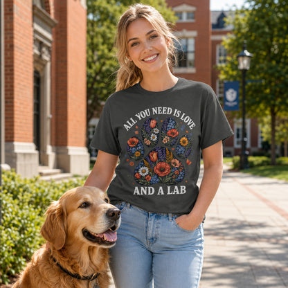 Woman sitting on a couch with her Labrador, wearing pepper 'All You Need Is Love And A Lab' t-shirt
