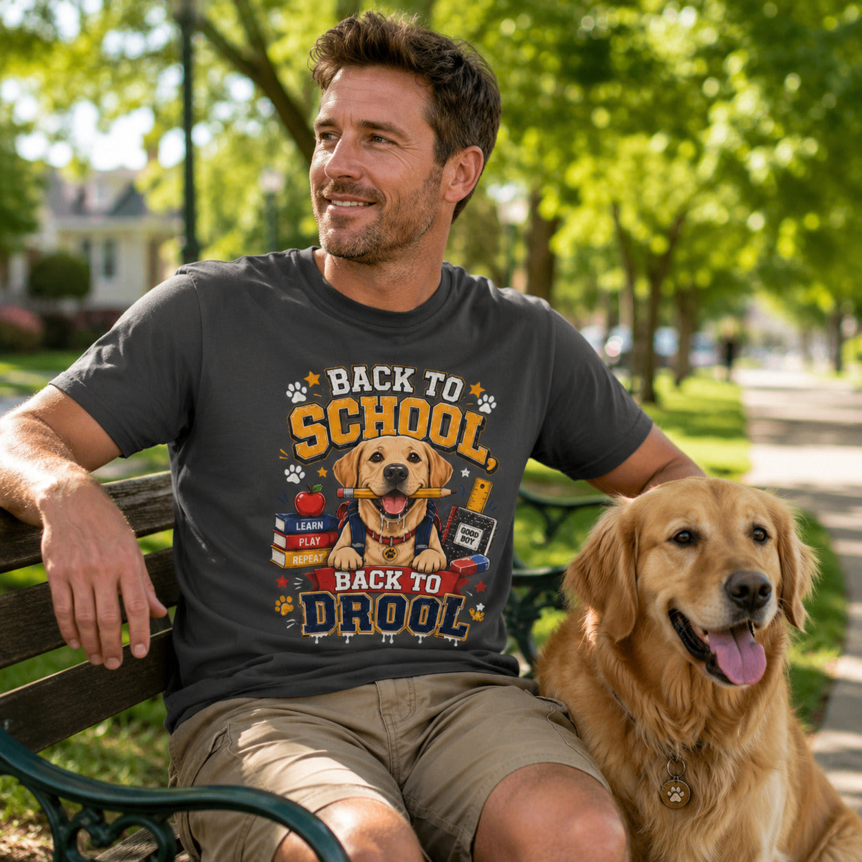 Man sitting on a bench with his golden retriever, wearing graphite 'Back to School, Back to Drool' dog t-shirt