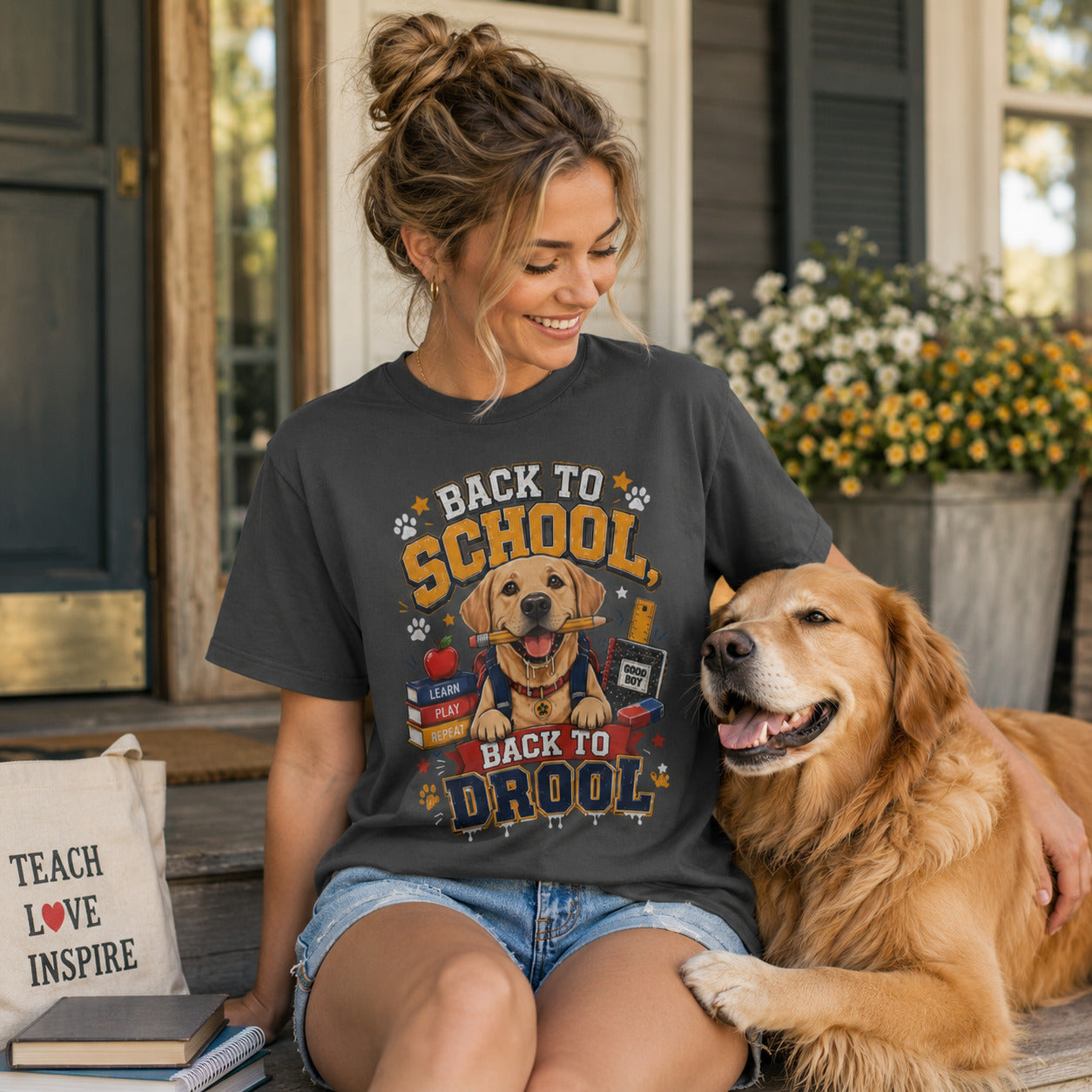 Woman sitting with a 'Teach Love Inspire' tote bag and her golden retriever, wearing graphite back to school dog t-shirt