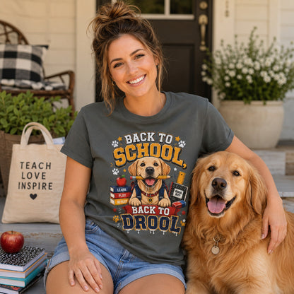 Woman sitting with a 'Teach Love Inspire' tote bag, apple, and books beside her golden retriever, wearing pepper back to school dog t-shirt