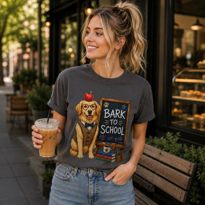 Young woman wearing a graphite Bark To School Golden Retriever Teacher T-shirt while walking with an iced coffee in a city coffee district, showcasing the bright Golden Retriever classroom graphic.