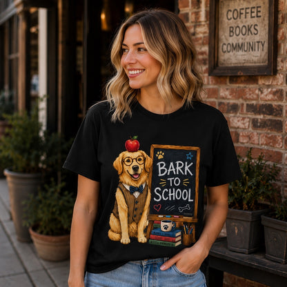 Smiling woman wearing a black Bark To School Golden Retriever T-shirt in front of a coffee shop, showcasing the centered Golden Retriever back-to-school artwork.