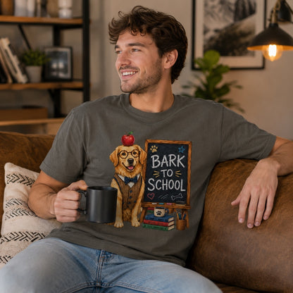 Young man wearing a Pepper “Bark to School” Golden Retriever teacher T-shirt while relaxing with a coffee mug in a modern living room.