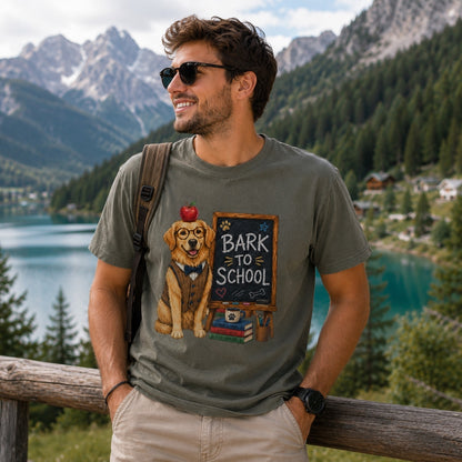 Young man wearing a Comfort Colors Pepper “Bark to School” Golden Retriever teacher T-shirt overlooking a scenic mountain lake.