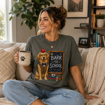 Woman relaxing on a sofa wearing a Pepper “Bark to School” Golden Retriever teacher T-shirt while enjoying coffee in a cozy living room.