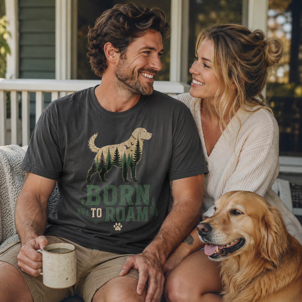 Couple sitting on a porch with mugs and their golden retriever, wearing graphite 'Born to Roam' dog t-shirts
