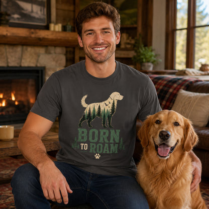 Man sitting by a fireplace with his golden retriever, wearing graphite 'Born to Roam' dog t-shirt