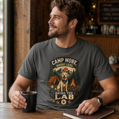 Man wearing a pepper Camp More Worry Less Bring The Lab T-shirt with coffee and notebook accessories while the Labrador camping graphic remains clear.