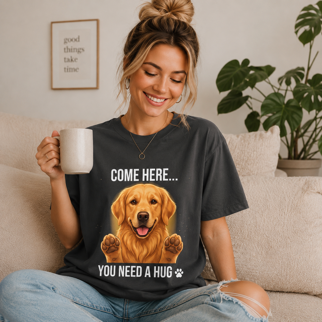 Woman wearing a graphite Come Here You Need a Hug t-shirt with a Golden Retriever while holding a coffee mug indoors