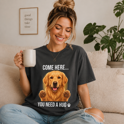 Woman wearing a graphite Come Here You Need a Hug t-shirt with a Golden Retriever while holding a coffee mug indoors
