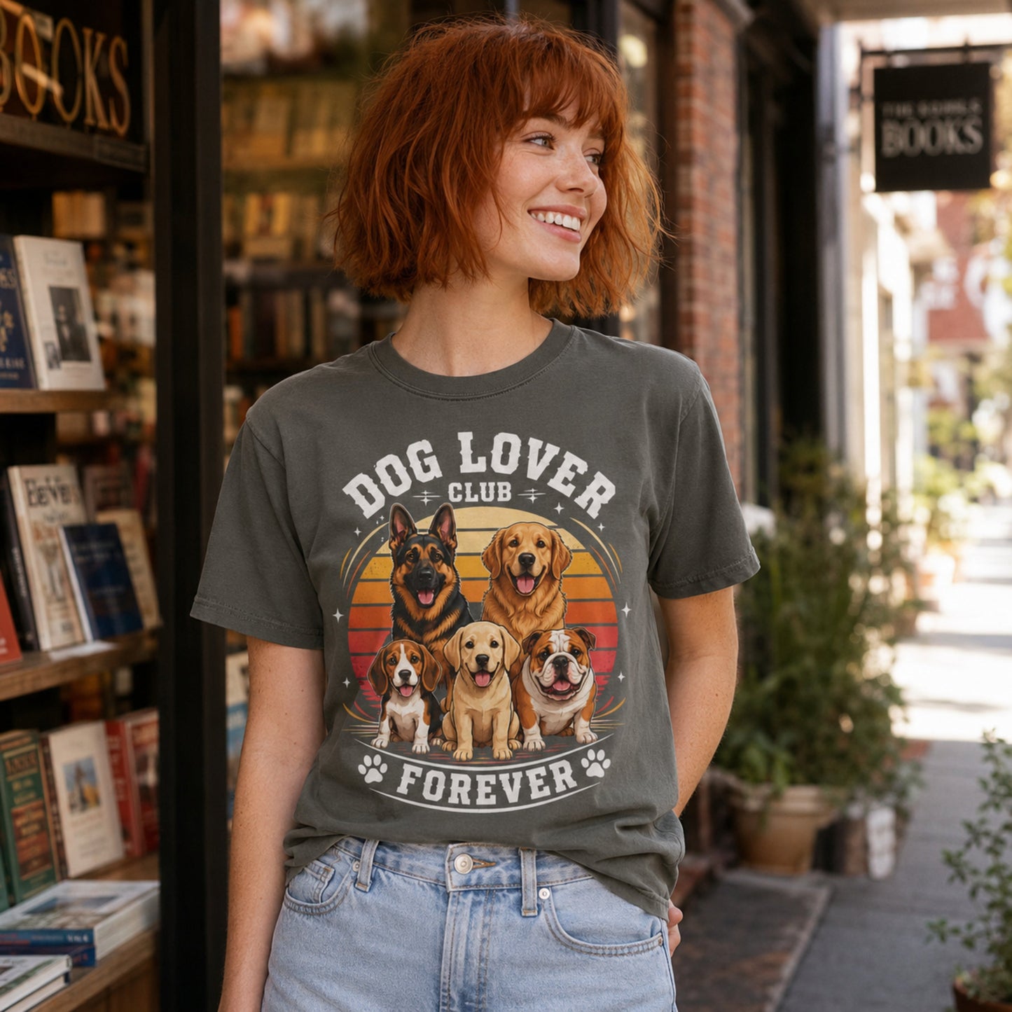 Woman wearing a pepper Dog Lover Club Forever T-shirt with multi-breed dog artwork outside a bookstore