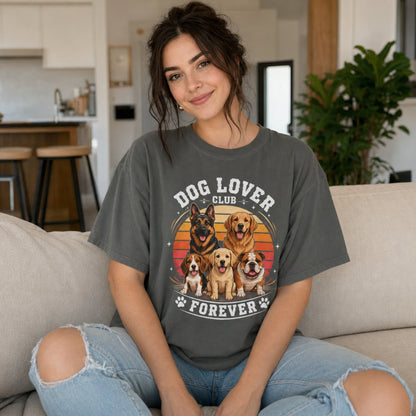 Woman wearing a pepper Dog Lover Club Forever T-shirt with multi-breed dog artwork while sitting on a sofa at home