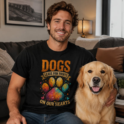 Man sitting on a couch with his golden retriever, wearing black 'Dogs Leave Paw Prints On Our Hearts' t-shirt