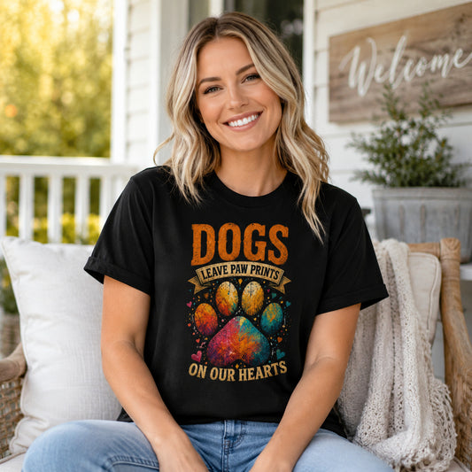 Woman standing on a porch near a 'Welcome' sign, wearing black 'Dogs Leave Paw Prints On Our Hearts' t-shirt