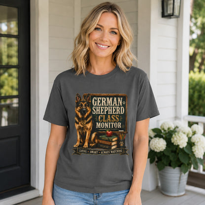 Woman standing on a porch surrounded by flowers, wearing pepper 'German Shepherd Class Monitor' t-shirt