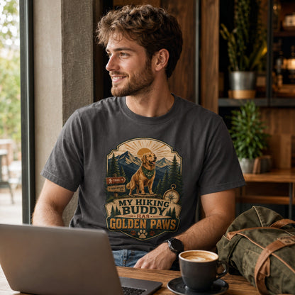 Man wearing a graphite My Hiking Buddy Has Golden Paws T-shirt in a coffee shop with a laptop and coffee.