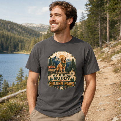 Man wearing a graphite My Hiking Buddy Has Golden Paws T-shirt on a lakeside hiking trail.