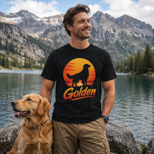 Man standing lakeside in front of mountains with his golden retriever, wearing black 'Golden Retriever Sunset' t-shirt