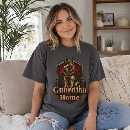 Woman wearing a graphite Guardian of the Home German Shepherd T-shirt while seated on a sofa.