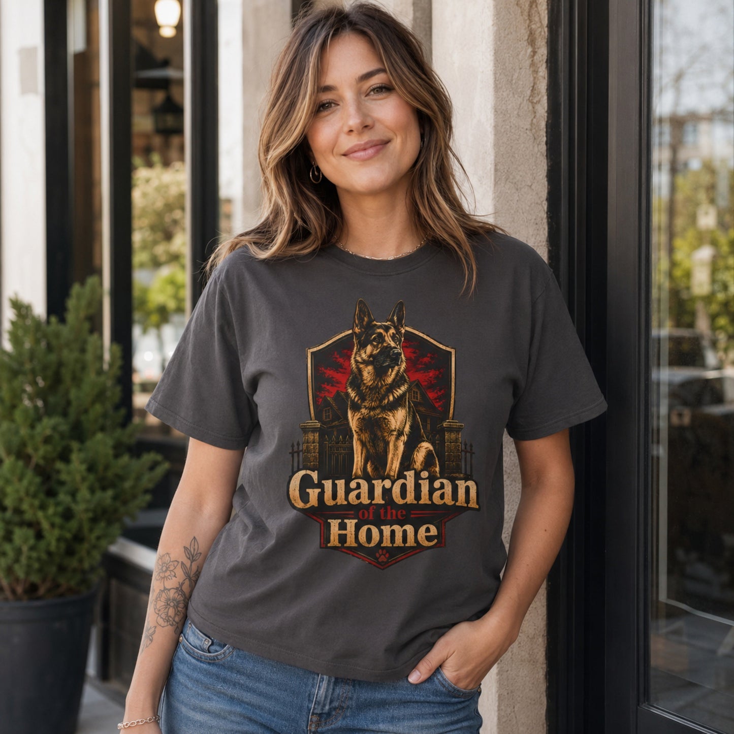 Woman wearing a graphite Guardian of the Home German Shepherd T-shirt outside a storefront.