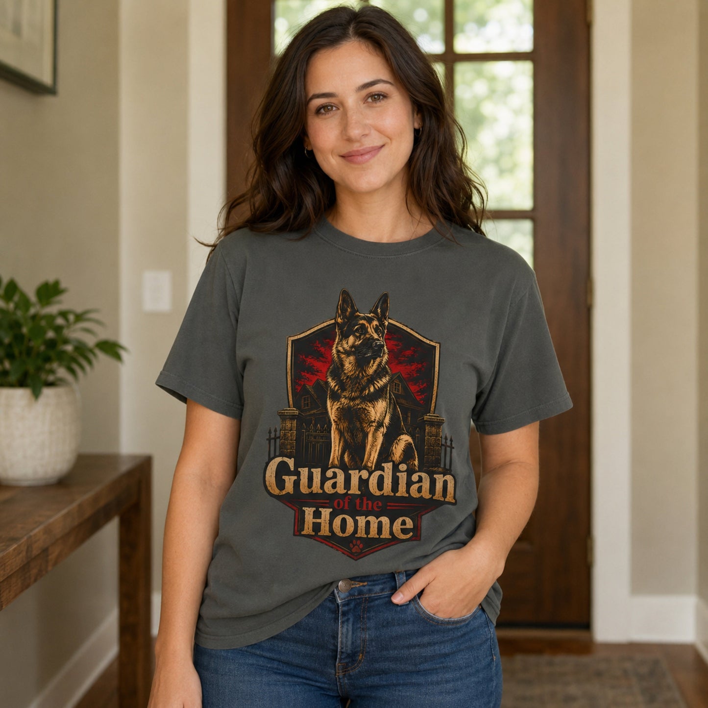 Woman wearing a pepper Guardian of the Home German Shepherd T-shirt in a home entryway.
