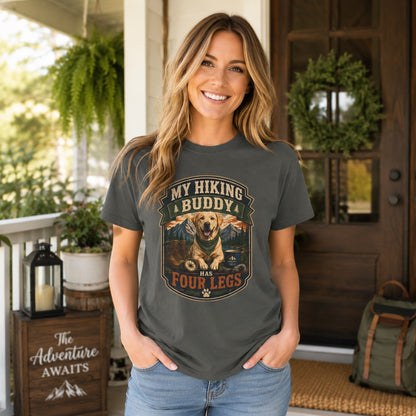 Woman with backpack standing at a porch entryway with an 'Adventure Awaits' sign, wearing pepper 'My Hiking Buddy Has Four Legs' dog t-shirt