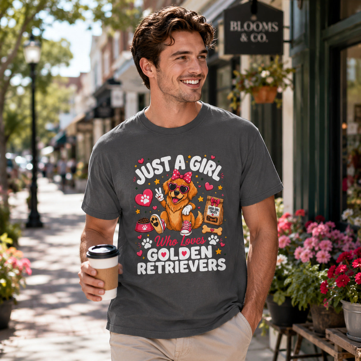 Man walking down a street holding coffee, wearing graphite 'Just A Girl Who Loves Golden Retrievers' t-shirt
