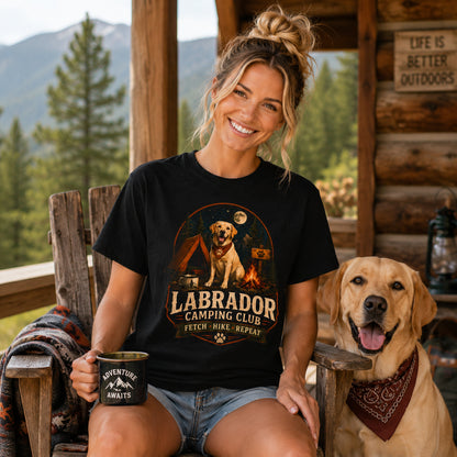 Woman wearing a black Labrador Camping Club Fetch Hike Repeat T-shirt with a Labrador at a mountain lodge.