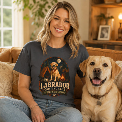 Woman wearing a graphite Labrador Camping Club Fetch Hike Repeat T-shirt with a Labrador at home.