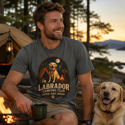 Man wearing a pepper Labrador Camping Club Fetch Hike Repeat T-shirt with a Labrador at a lakeside campsite.