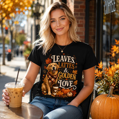 Woman sitting at an outdoor cafe table with iced coffee, wearing black 'Leaves Lattes & Golden Love' t-shirt