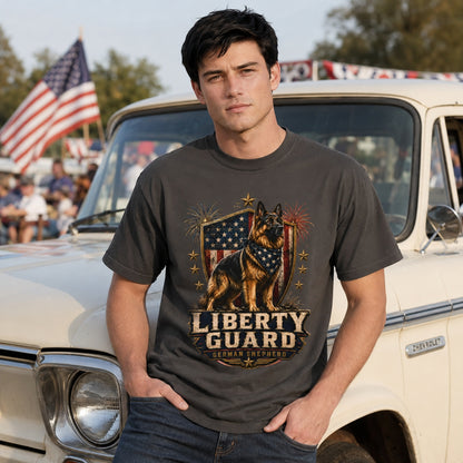 Man wearing a graphite Liberty Guard German Shepherd T-shirt near a patriotic truck scene with American flags.