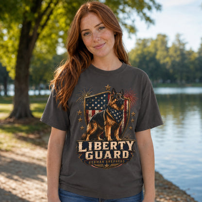 Woman wearing a graphite Liberty Guard German Shepherd T-shirt near a lakeside outdoor setting.