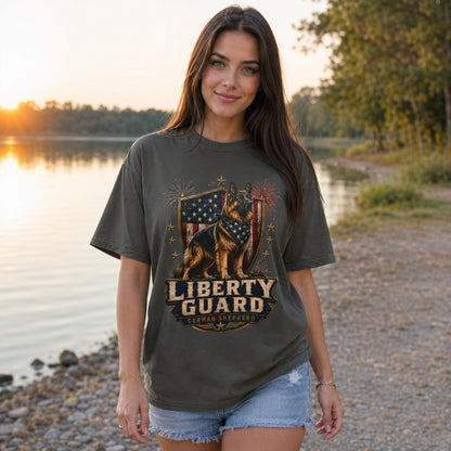 Woman wearing a pepper Liberty Guard German Shepherd T-shirt near a lakeside sunset outdoor setting.