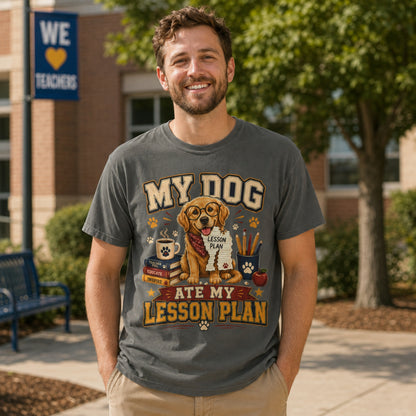 Man wearing a Pepper “My Dog Ate My Lesson Plan” T-shirt outdoors in a school courtyard with golden retriever teacher artwork.