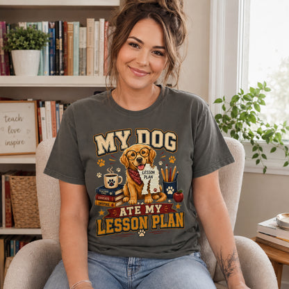 Woman wearing a Pepper “My Dog Ate My Lesson Plan” T-shirt indoors near a bookshelf with golden retriever teacher artwork.