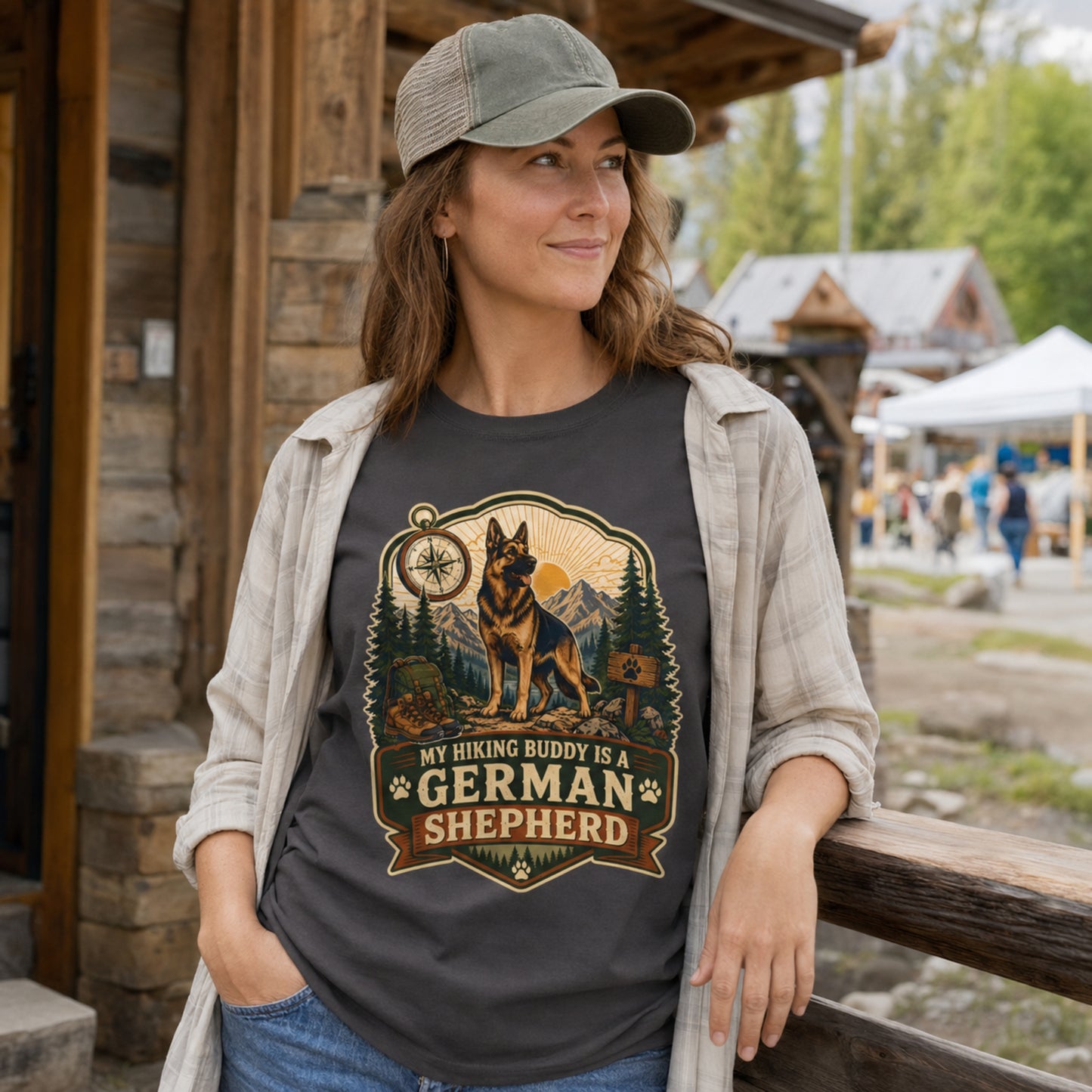 Woman wearing a graphite My Hiking Buddy German Shepherd T-shirt at an outdoor mountain market.