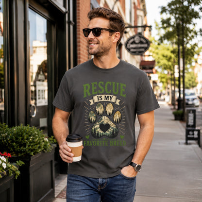 Man wearing a graphite Rescue Is My Favorite Breed T-shirt on a city street while holding coffee.