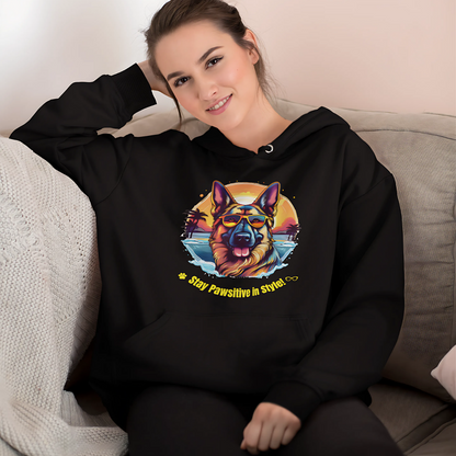 Woman wearing a black Stay Pawsitive in Style hoodie with a German Shepherd graphic while relaxing on a sofa at home.