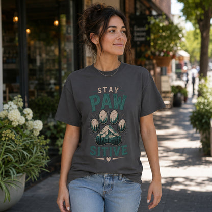 Woman wearing a graphite Stay Pawsitive T-shirt on a boutique street.